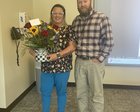 Photo of Andrew Knust presenting flower to Ann Stevens