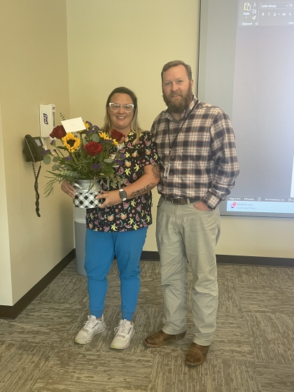 Photo of Andrew Knust presenting flower to Ann Stevens
