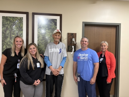 GH staff with Scott by the cancer bell donated by his family
