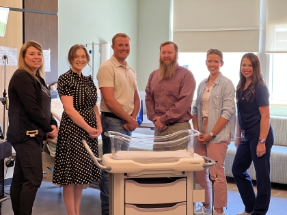 New bassinet with Foundation Board Members and Staff