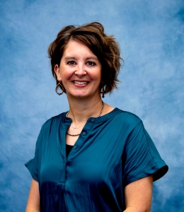 Headshot of Maria in blue dress shirt