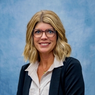 Claudine Kennicutt in a navy blazer and grey button-down blouse